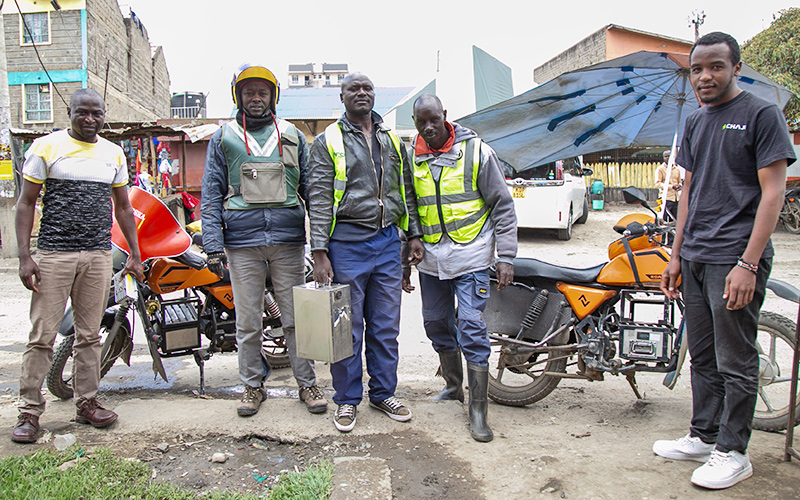 Employees posing together with e-mobility equipment
